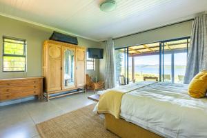a bedroom with a large bed and a large window at Midlands Lakehouse in Rosetta