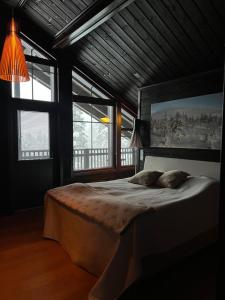 a bedroom with a large bed in a room with windows at Grand Hideout Levi in Kittilä