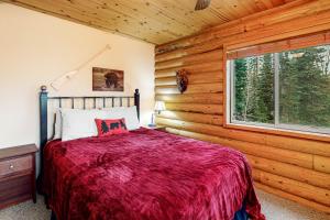 Dormitorio con cama y ventana en una cabaña en Heavenly Haven, en Brian Head