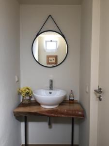 a bathroom with a white sink and a mirror at Chalet Tropical in Arco da Calheta
