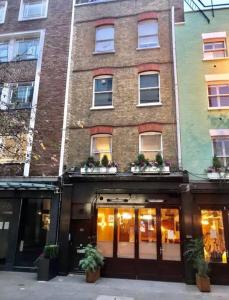 un grand bâtiment en briques avec des fenêtres et des plantes. dans l'établissement Chic Flat in Oxford Circus, à Londres