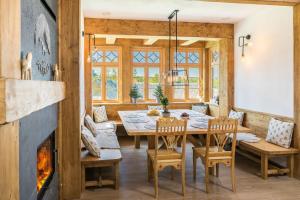 una sala da pranzo con tavolo, sedie e camino di Rent like home - Willa Zoniówka PREMIUM a Zakopane