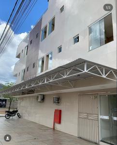 ein Gebäude mit einem unter einer Metallkonstruktion geparkten Motorrad. in der Unterkunft Seller Hotel in Sobral