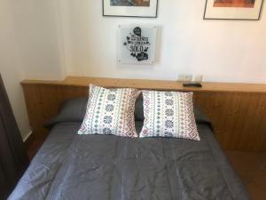 a bed with two pillows on top of it at Plaza Andalucia Edificio Dornajo 215 in Sierra Nevada