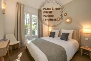 sypialnia z łóżkiem i znakiem na ścianie w obiekcie Farniente Saint Tropez IV w Saint-Tropez