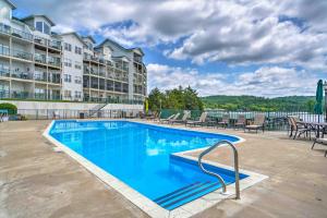 a pool at a resort with chairs and tables at Camdenton Condo with Patio, Pool and Lake Access! in Camdenton