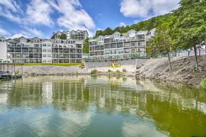 a large apartment building next to a body of water at Camdenton Condo with Patio, Pool and Lake Access! in Camdenton