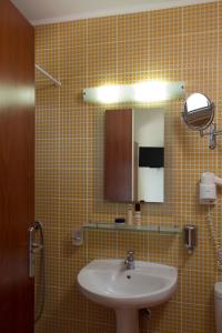 een badkamer met een wastafel en een spiegel bij Hotel Livikon in Plakias