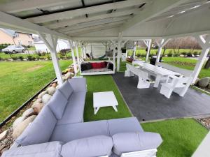 eine Veranda mit weißen Sofas und einem Picknicktisch in der Unterkunft BLACK & WHITE HOUSES in Niedzica