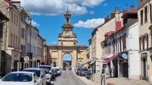 a building with a clock tower in the middle of a street at Le Coeur de Pontarlier in Pontarlier