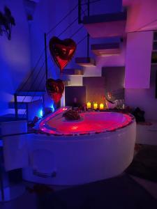 Camera dotata di vasca da bagno con luci rosse e scale. di Affittacamere La Magnolia a Bacoli