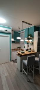 uma cozinha com armários verdes e uma mesa e cadeiras em L'alloggetto sul Corso em Cuneo