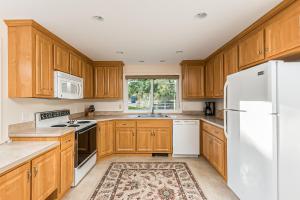 a kitchen with wooden cabinets and a white refrigerator at Mill Pond Vista in Chatham