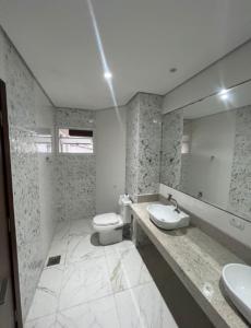 y baño con aseo, lavabo y espejo. en HOSTEL FAMÍLIA CASTOR en Itanhaém
