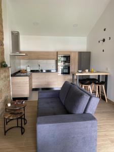 ein Wohnzimmer mit einem blauen Sofa und einer Küche in der Unterkunft A CASA D'ABAIXO in Cee