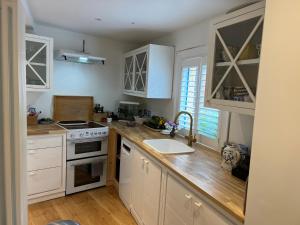 a kitchen with white cabinets and a sink at Double Room at Minster Cottage in Kings Lynn