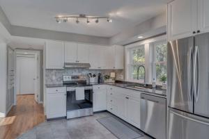 a kitchen with white cabinets and stainless steel appliances at The Cottage @ Afton Mountain- Close to Wineries! in Afton