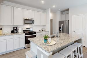 a kitchen with white cabinets and a granite counter top at Serenity House on Kingwood in Porter