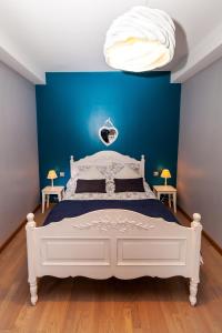 een slaapkamer met een wit bed en een blauwe muur bij Appartement d'une chambre avec vue sur la ville terrasse et wifi a Charleville Mezieres a 4 km de la plage in Charleville-Mézières