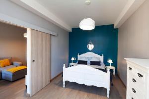 a bedroom with a white bed and a blue wall at Appartement d'une chambre avec vue sur la ville terrasse et wifi a Charleville Mezieres a 4 km de la plage in Charleville-Mézières