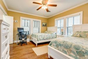 a bedroom with two beds and a desk and a fan at Nautical Niche-Master in Galveston