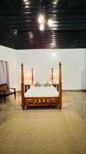 a bedroom with a wooden bed in a room at Gundumala Planters Bungalow - Tentgram in Suryanelli