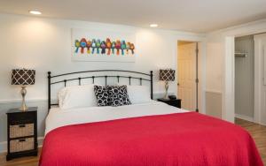 um quarto com uma cama grande e um cobertor vermelho em Glen Cove Inn & Suites Rockport em Rockport