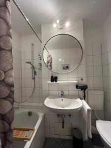 a bathroom with a sink and a shower and a mirror at Ferienwohnung AllgäuSchatz in Stadtnähe Kempten in Lauben