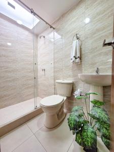 a bathroom with a toilet and a shower and a sink at Como en tu casa apartamento oeste in Cali