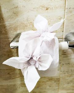a toilet paper holder with a white flower on it at Como en tu casa apartamento oeste in Cali