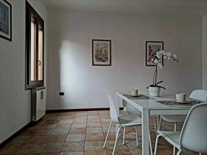 a dining room with a white table and chairs at Ca' Piave in Mestre +11 photos