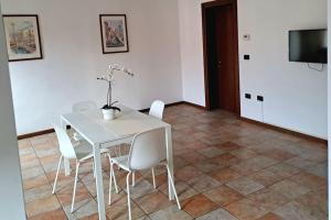 a white dining room table with white chairs and a television at Ca' Piave in Mestre