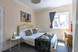 una camera da letto con un letto, un tavolo e una finestra di Wow Look Central 2bed Parking Next To Hospital a Southampton