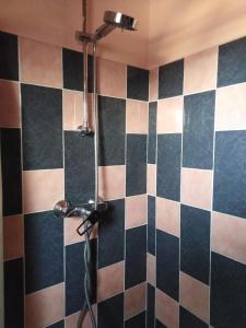 y baño con ducha y pared de azulejos blancos y negros. en Etoile, en Questembert