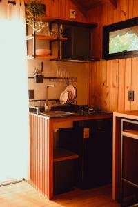 uma cozinha com um lavatório e um fogão forno superior em Cabanas Por do Sol em Garopaba
