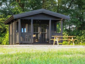 une petite cabine avec un banc devant elle dans l'établissement Holiday Hut, à Bornerbroek