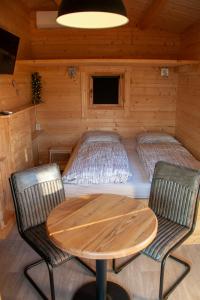 une chambre avec une table et des chaises dans une cabine dans l'établissement Holiday Hut, à Bornerbroek