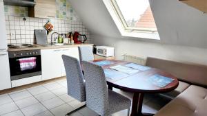 a small kitchen with a wooden table and chairs at Monteurwohnung Ha-Wei -90 m2 in Hangen-Weisheim