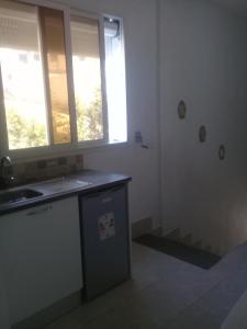 a kitchen with a sink and two windows at les grottes de bizerte in Bizerte