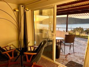 a room with a glass table and chairs and a patio at The State Room - Cliffside, Ocean Views in Kodiak