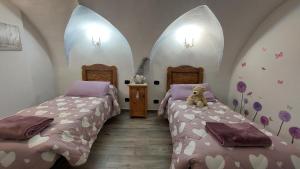 a bedroom with two beds and a teddy bear sitting on the bed at L'Antica Canonica di Casa Bernardi, terrazzo Wi-Fi PetFriendly con Area Cani in Trento