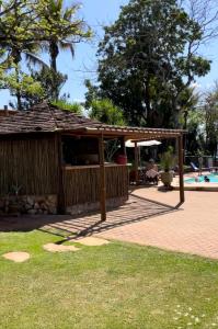 a wooden pavilion next to a swimming pool at Pousada da Pedra Rifaina in Rifaina