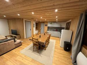 a living room with a table and a kitchen at Magnifique appartement rénové in Seytroux