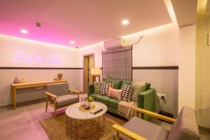 ein Wohnzimmer mit einem grünen Sofa und einem Tisch in der Unterkunft Olive Indiranagar 100ft Road - by Embassy Group in Bangalore