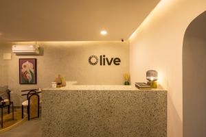 Olive Indiranagar 100ft Road - by Embassy Group في بانغالور: غرفة مع منضدة مع علامة على الحائط