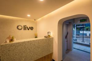 um lobby com um sinal que lê ao vivo na parede em Olive Indiranagar 100ft Road - by Embassy Group em Bangalore