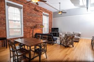 a living room with a table and a brick wall at Modern Lofts next to Georgia St. & Convention Ctr. in Indianapolis