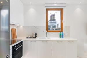 biała kuchnia ze zlewem i oknem w obiekcie Karolkowa 28 - Prestigious Apartment with Balcony by Renters Prestige w Warszawie