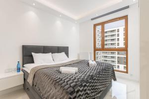 biała sypialnia z dużym łóżkiem i oknem w obiekcie Karolkowa 28 - Prestigious Apartment with Balcony by Renters Prestige w Warszawie