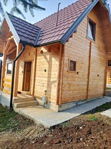 una pequeña casa de madera con porche en Vila Planinski san 1, en Zaovine